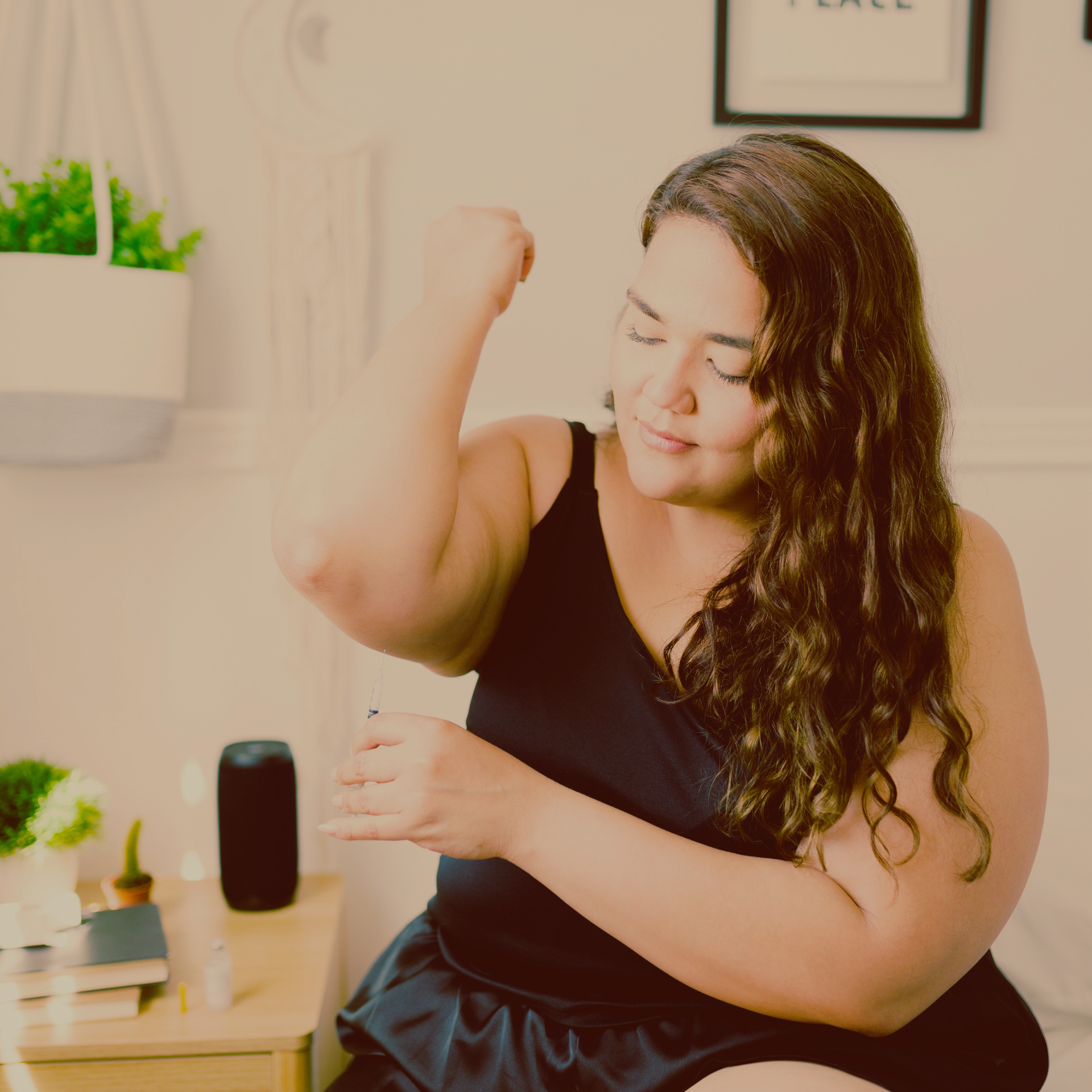 Woman in a black shirt giving herself an injection of her medication.